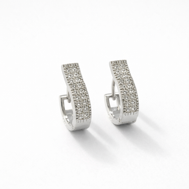 Maribella Huggie Earrings, silver crystal huggie earrings with hinged closure on background.