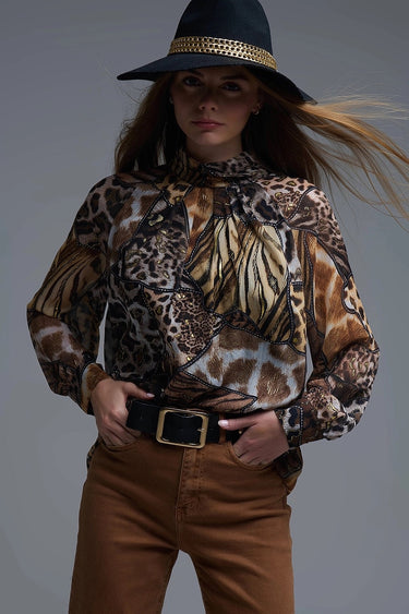 Flowy animal-print blouse with golden accents in brown and black tones, shown on model styled with hat and brown pants — Marisma Blouse by Matte.