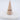 A clip ring with gold plated design displayed on a beige conical stand.