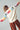 Model wearing ivory knit sweater with colorful MERRY CHRISTMAS lettering on sleeves and back.