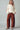 Model wearing ivory knit sweater with colorful MERRY CHRISTMAS lettering on sleeves and back.