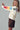 Side view of oversized Christmas knit sweater styled with brown corduroy pants.