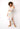 Woman wearing a pastel twist-front crop top in soft sunset tones — lightweight resort style by Matte.