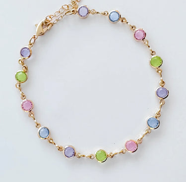 Delicate gold bracelet with pastel stones laid on white surface — Mirlo Bracelet by Matte.