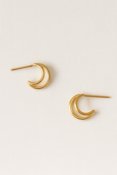 Moon Stud Earrings — gold-plated crescent-shaped earrings with smooth mirror finish on linen background, minimal and elegant by Matte.