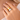 Close-up of a hand wearing a gold and silver ring on a neutral background by matte jewelry