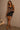 Leopard-print cami with black lace trim, slim straps, and an asymmetric hem, styled with a black mini skirt.
