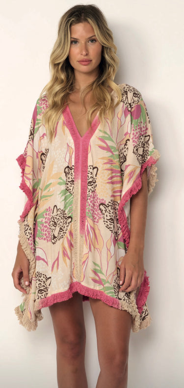 Woman wearing Nairobi Tunic Cover Up in tropical pink and beige print, relaxed fit with fringe detail.
