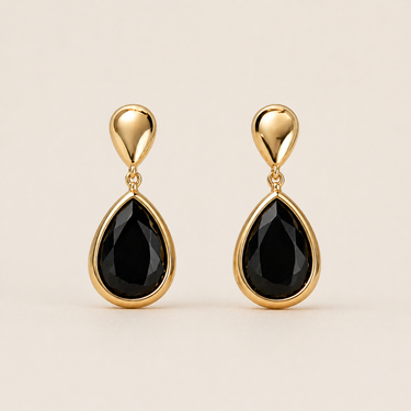 Nodar Stud Earrings gold earrings with black teardrop stones on neutral background, showing polished gold setting and bold contrast design