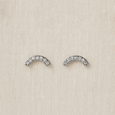 silver arc-shaped Nolan stud earrings with crystals on linen backdrop — minimalist sparkle studs by Matte