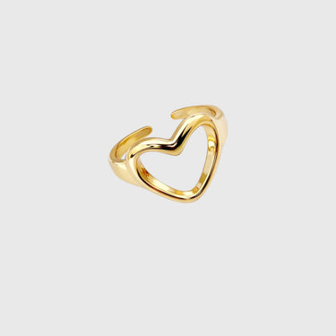 Gold heart-shaped ring on a light gray background