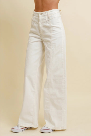 Nurcia Jeans angled side view highlighting wide-leg shape, smooth fitted waistband, and slightly oversized leg opening in ivory denim.
