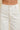Nurcia Jeans close-up front waist detail showing button closure, belt loops, front pockets, and structured high-rise fit in cream denim.