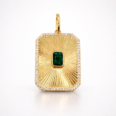 Nuwa Pendant gold rectangular charm with textured sunburst finish and green center stone on a light gray background with soft shadow