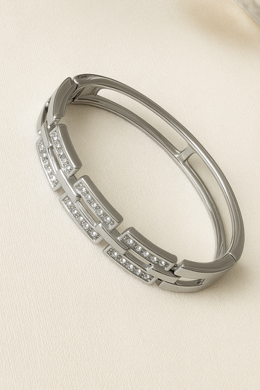 Odie Bangle Bracelet — polished gunmetal silver bangle with crystal accents on beige linen background, sleek and reflective by Matte.