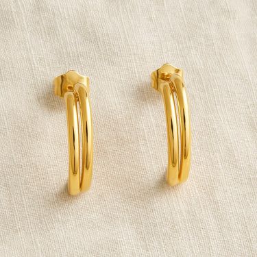 Gold double-band hoop earrings on white linen backdrop, Oli Hoop Earrings.