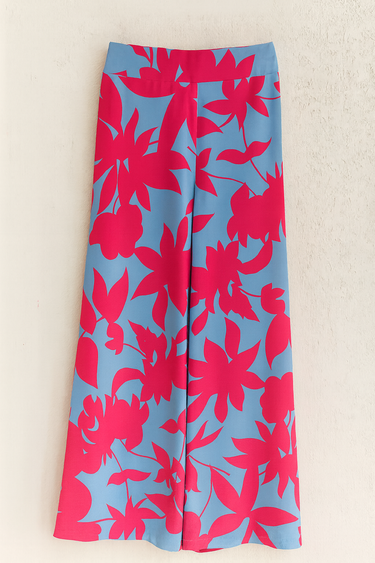 Floral patterned pants with pink flowers on a blue fabric.