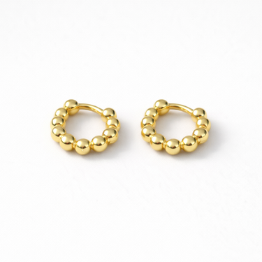 Quiet Huggie Earrings petite gold beaded huggie earrings on white background.