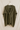 Quiton Poncho Cape — olive green ribbed knit wrap with self-tie front, shown hanging on beige wall, cozy fall accessory from Matte.