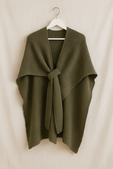 Quiton Poncho Cape — olive green ribbed knit wrap with self-tie front, shown hanging on beige wall, cozy fall accessory from Matte.