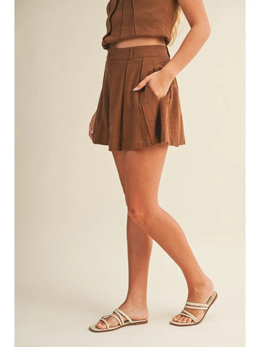 Ragit Short brown tailored shorts side profile view, highlighting fluid drape, pleated front detail, and flattering high-rise cut.