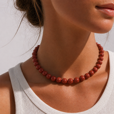 Ravn Necklace red beaded necklace worn on neck with white top, showing bold glossy beads and statement fit at neckline