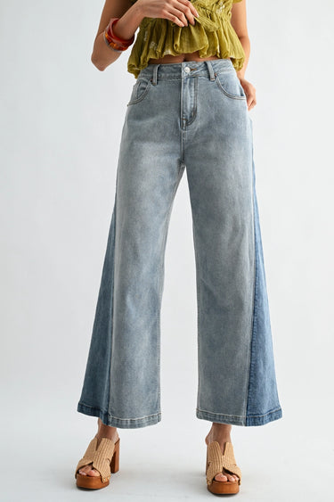 Person wearing light blue wide-leg jeans on a white background