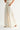 Rumi Pant cream wide-leg trousers side profile view showing flowing drape and relaxed elegant leg line.