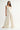 Rumi Pant cream wide-leg trousers styled in a minimal resort look with relaxed top and sandals, showcasing effortless European summer aesthetic.