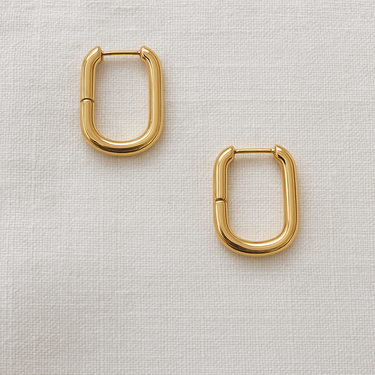 Runa Huggie Earrings — rectangular gold plated hoops on linen background, modern, lightweight, and elegant jewelry piece by Matte.