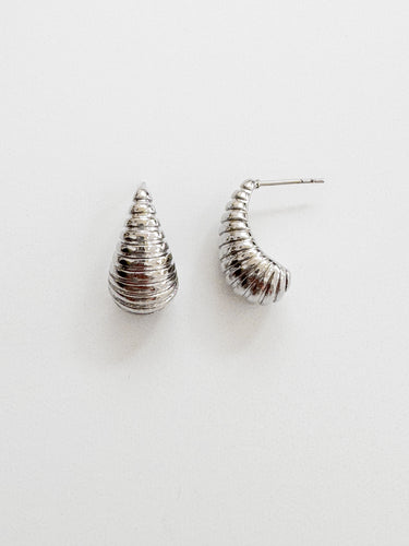 Sage Stud Earrings — sculpted silver-plated spiral stud earrings on white linen background, minimalist polished jewelry by Matte.