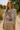 Woman wearing a sweater with a pink leopard design in a natural setting