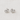 Kuga Stud Earrings featuring silver heart-shaped settings with clear crystals on a soft beige fabric background.