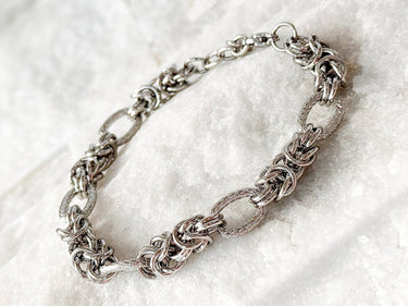 Silver chain bracelet with intricate link design on marble stone background – Solea Chain Bracelet Matte Jewelry