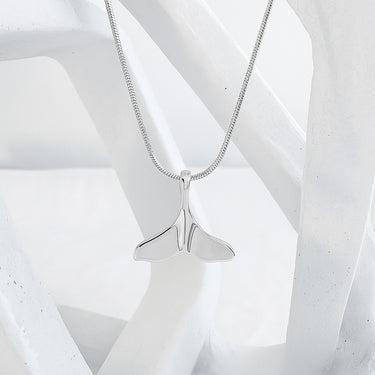 Silver whale tail necklace on a white background