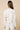 Tuci Jacket worn by model, back view, highlighting embroidered texture and clean relaxed shape.