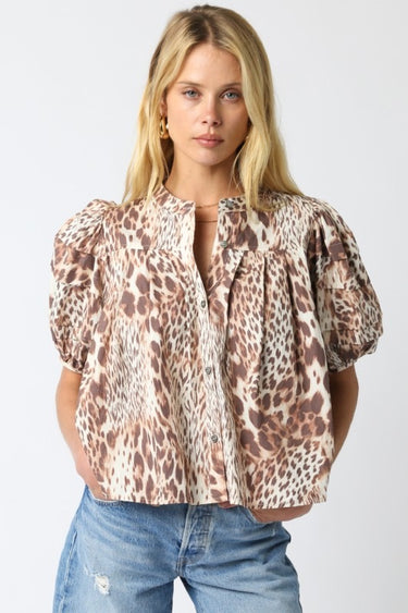 Tyrath Blouse leopard print blouse with puff sleeves and button-front design, featuring a relaxed airy fit and neutral animal print, styled with blue denim on model against white studio background.