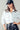 White cropped utility jacket with front pockets, styled casually