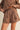 Brown outfit with eyelet details on a plain background