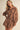 Woman wearing a brown lace dress against a beige background