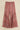 Pink and purple bohemian printed wide-leg pants with flared tiered hem and elastic waist — resort look.