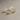 Close-up of gold stud earrings with 5 mm round cubic zirconia on a neutral cement background – Vivia Stud Earrings by Matte