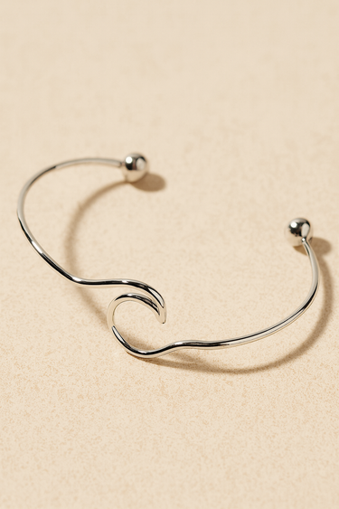 Waves Cuff Bracelet — sculptural silver open cuff bracelet with wavy design and polished sphere ends on beige background, minimal and elegant by Matte.
