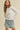 Model wearing white Essential Long Sleeve Tee by Matte with denim shorts, front view
