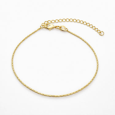 Whizat Bracelet delicate gold chain bracelet with fine structured links on a light gray background with soft shadow.