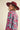 Woman walking in sky blue floral knit sweater with pink floral pattern, styled with hat