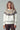 Back view of Zermatt Sweater, fair isle knit in cream with taupe and brown yoke, styled with brown pants.