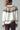 Full-body model shot in Zermatt Sweater, cream fair isle knit with brown pants and suede ankle boots.