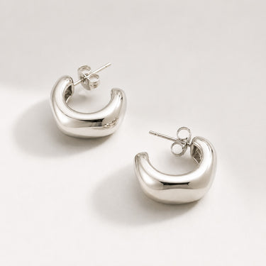 Acura Hoop Earrings featuring polished silver sculptural hoop earrings with a bold puffed crescent silhouette, smooth mirror finish, lightweight hollow design, secure post-back closure, and modern statement style.