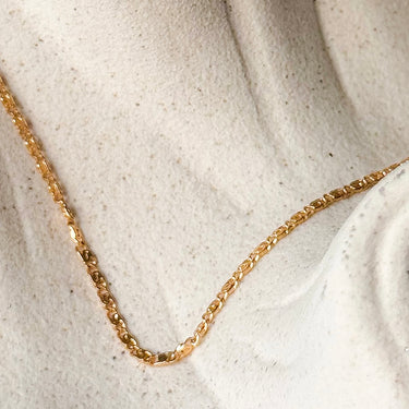 Aluna Necklace by Matte, gold plated flat chain on cream textured surface